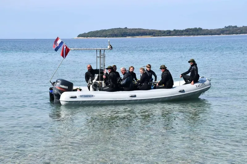Groupe de plongeurs à bord d'un bateau semi-rigide en mer