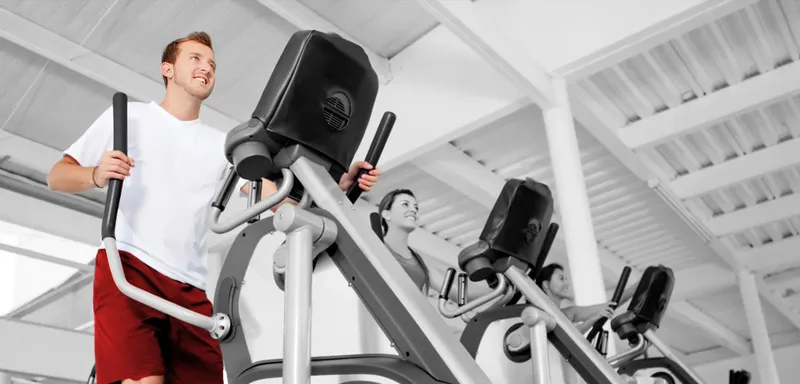 Des personnes s'entrainent sur des appareils de cardio en salle