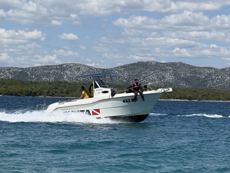 Bateau de plongée blanc navigue sur une mer bleue ensoleillée
