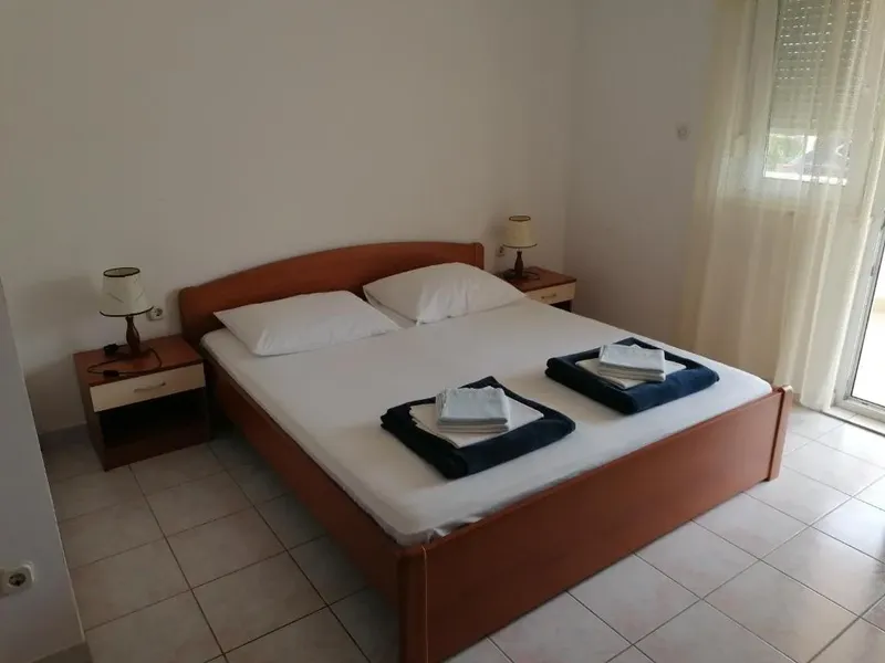 Chambre d'hôtel simple avec un lit double et des tables de chevet