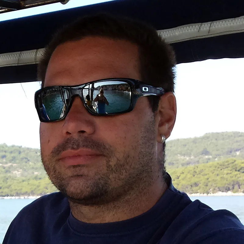 Portrait d'un homme barbu avec des lunettes de soleil sur un bateau