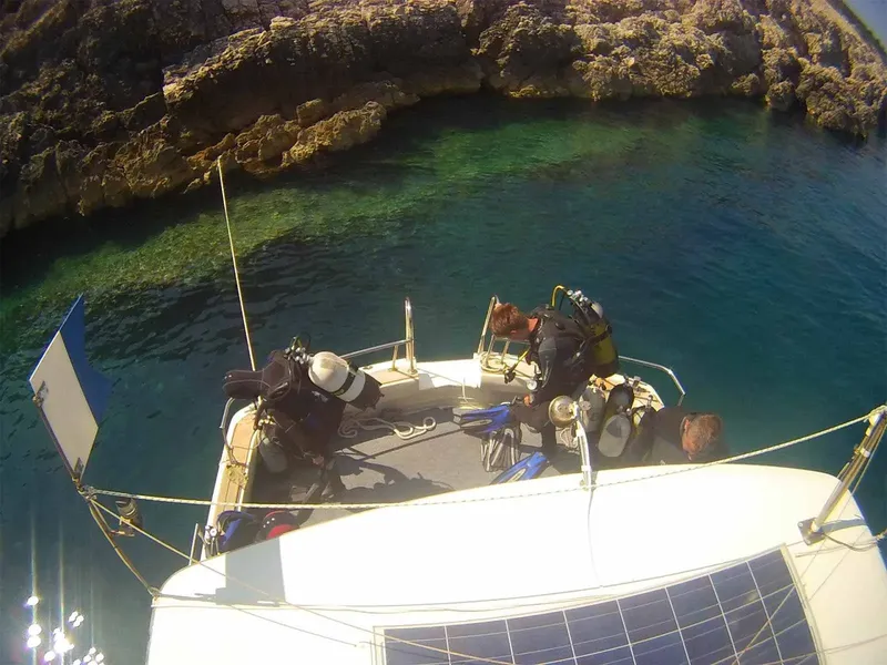 Plongeurs équipés sur le pont d'un bateau en mer turquoise