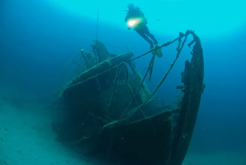 Plongeur explorant l'épave d'un bateau coulé en milieu marin