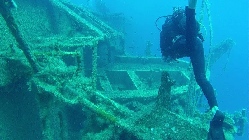 Plongeur explorant l'épave d'un bateau sous-marin, lumière bleue