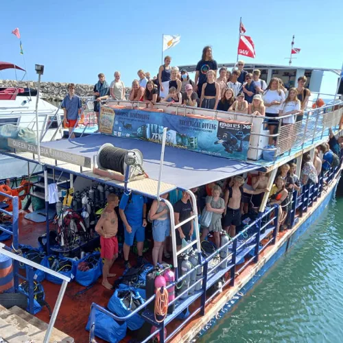 Groupe de plongeurs sur un bateau avec équipement et drapeaux