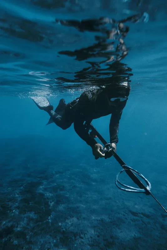Apnea, un plongeur en combinaison noire nage vers le haut