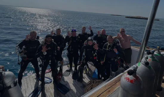 Groupe de plongeurs souriants sur le pont d'un bateau en mer