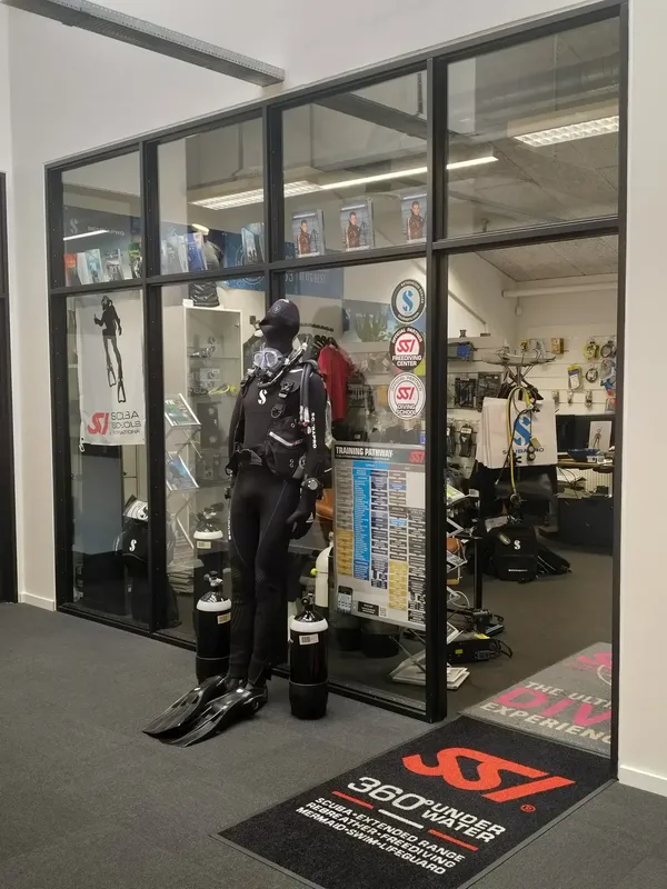 Entree d'un centre de plongee avec manequin en combinaison et equipement