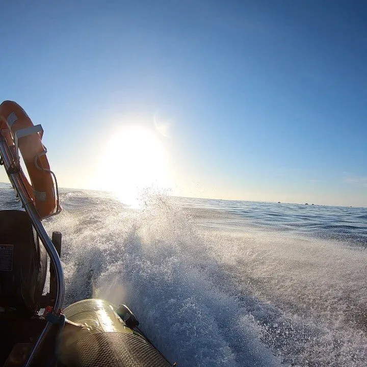 Bateau de plongée en mer, éclaboussures, soleil éclatant, ciel bleu clair