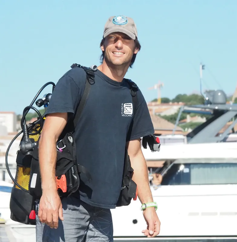 Plongeur souriant avec équipement complet sur un port ensoleillé