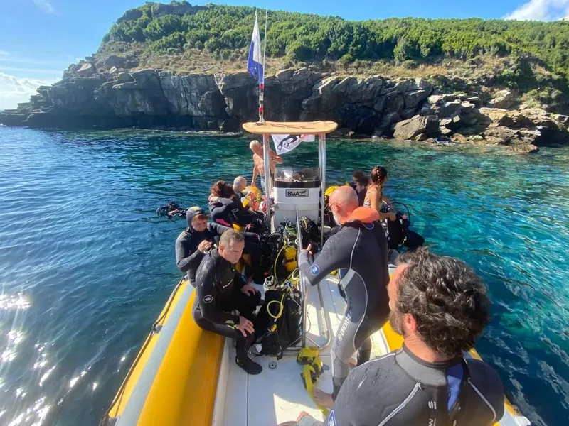 Groupe de plongeurs en combinaison sur un bateau semi-rigide en mer