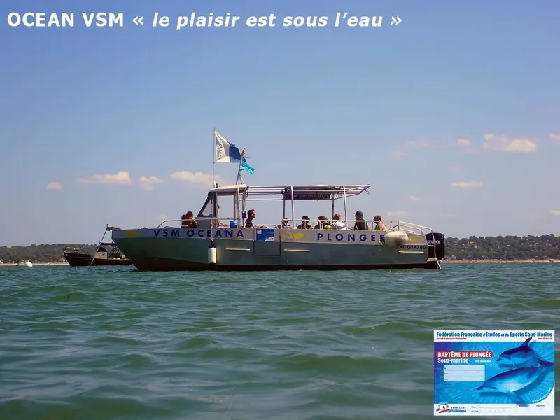 Bateau de plongée jaune et bleu sur une mer calme ensoleillée