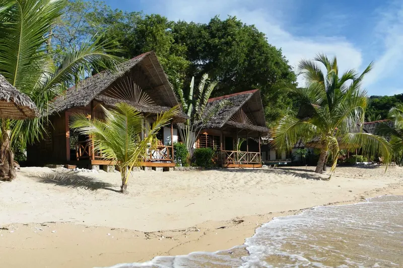 Cabanes en bois sur une plage de sable blanc tropicale