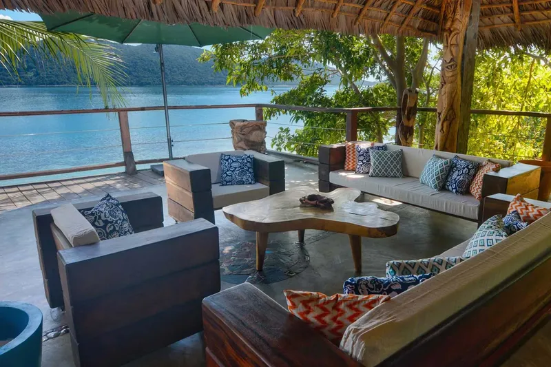 Espace détente extérieur avec canapés, table basse et vue sur mer