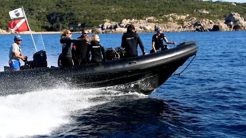 Plongée : un semi-rigide transporte des plongeurs en combinaison sur l'eau