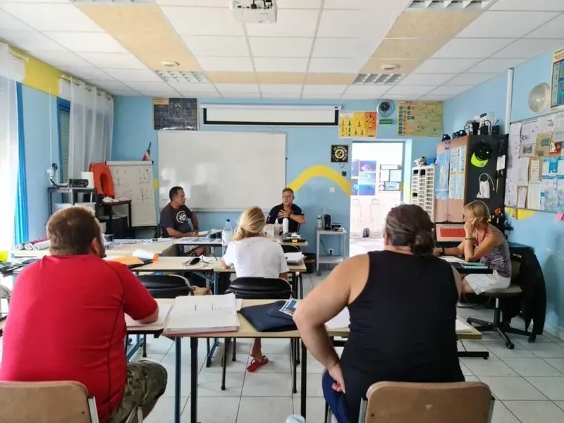 Cours de plongée en salle avec instructeurs et participants attentifs