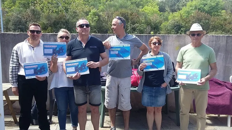Groupe de personnes souriantes tenant des certificats de plongée