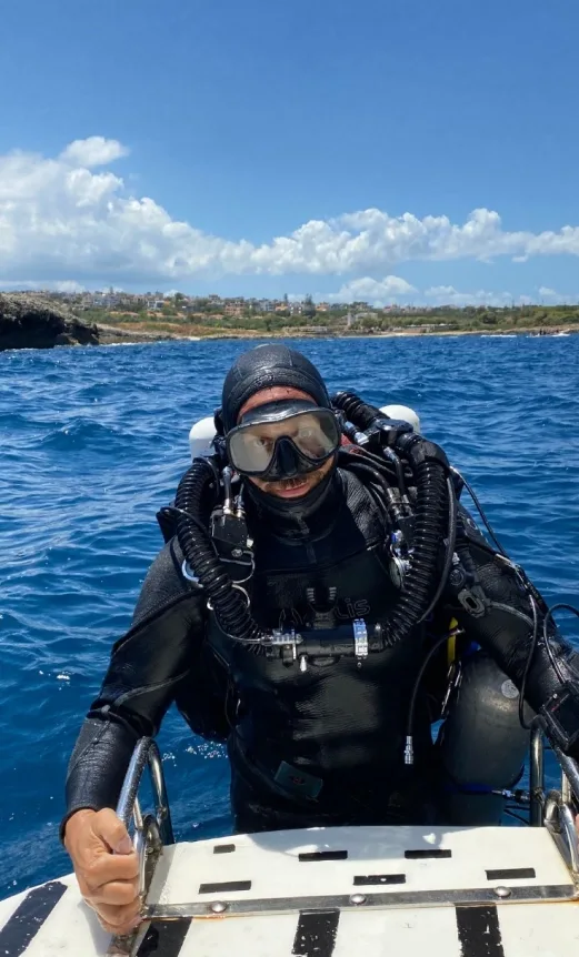Plongeur équipé sur un bateau, prêt à explorer les fonds marins