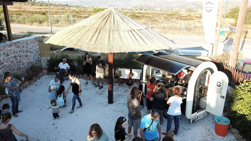 Groupe de personnes se rassemblant devant une structure couverte et un local