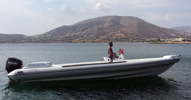Un homme conduit un bateau semi-rigide sur une mer calme