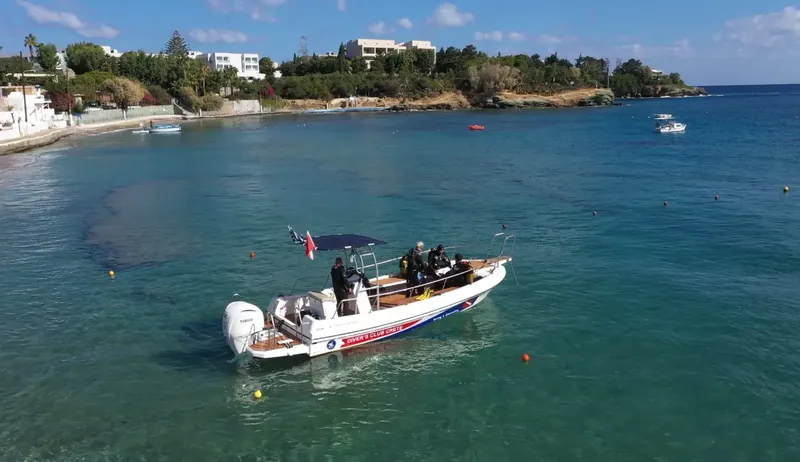 Bateau de plongée avec des plongeurs en mer, paysage côtier ensoleillé