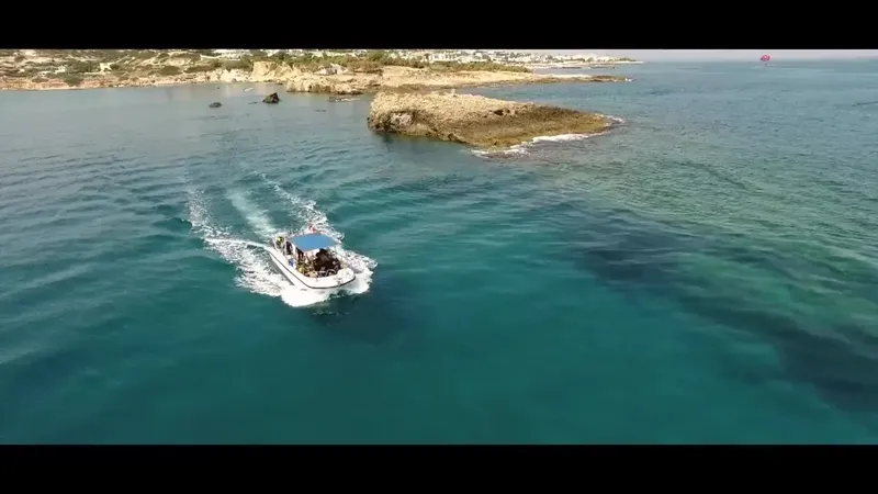 Bateau de plongée navigue sur une mer turquoise près des côtes rocheuses