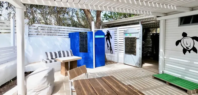 Espace détente extérieur avec mobilier, mur peint et décorations marines