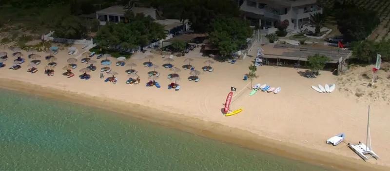 Vue aérienne d'une plage avec des personnes, bateaux et bâtiments