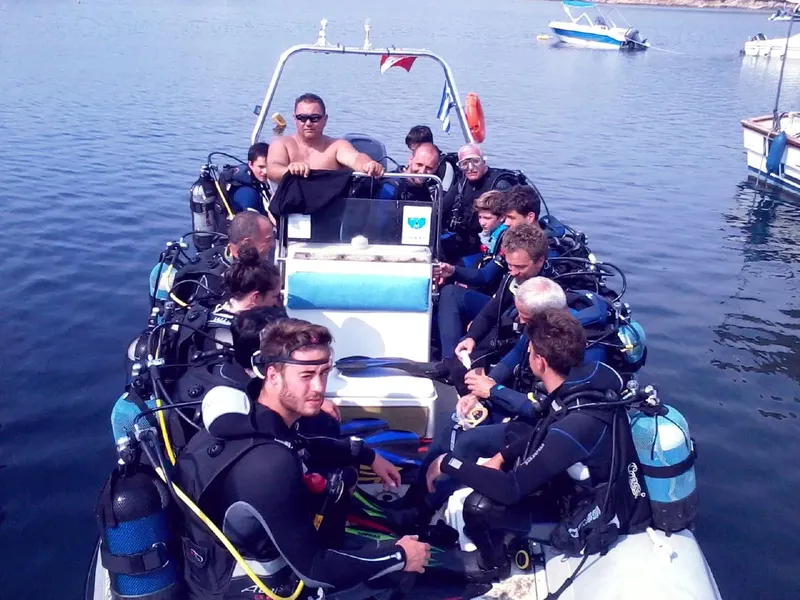 Groupe de plongeurs équipés à bord d'un bateau semi-rigide en mer