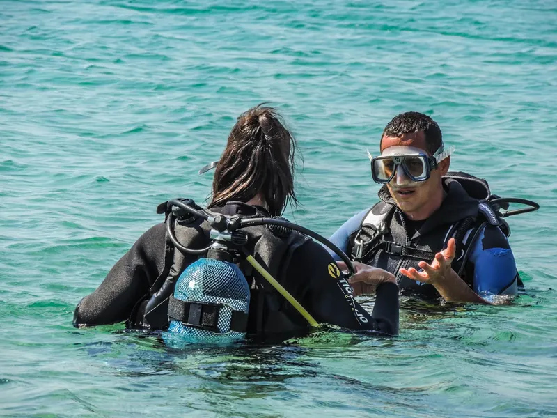Deux plongeurs discutent à la surface de l'eau turquoise