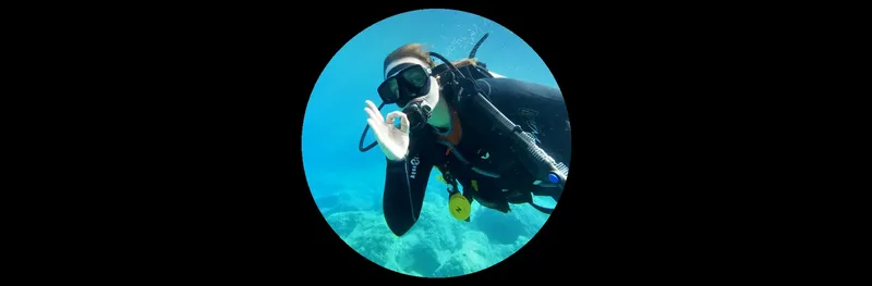 Plongeur souriant avec signe OK, équipé en pleine exploration sous-marine