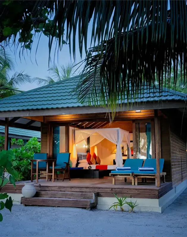 Intérieur d'une chambre avec moustiquaire sur une terrasse tropicale