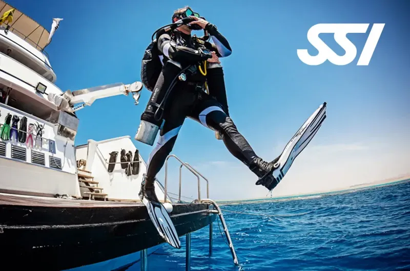 Plongeur s'apprête à sauter d'un bateau en combinaison complète