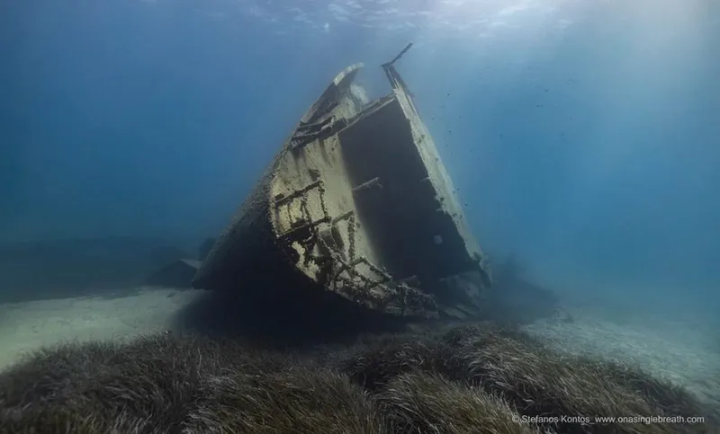 Épave de bateau coulé reposant sur un fond marin sablonneux