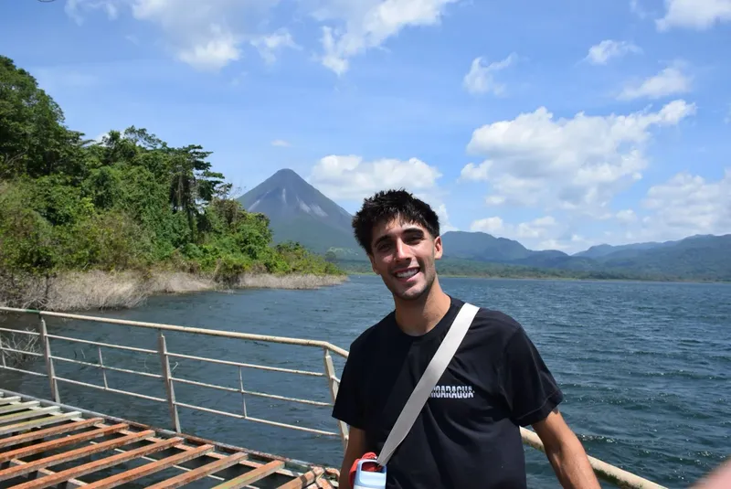 Un homme souriant se tient sur un ponton au bord de l'eau