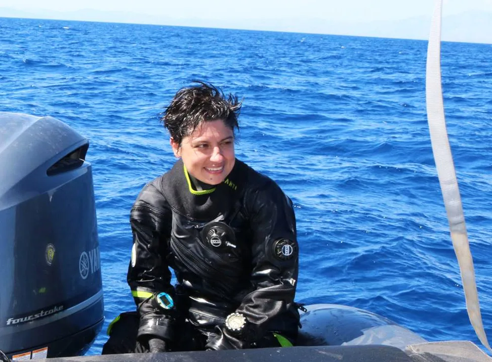 Plongeuse souriante en combinaison sur un bateau en mer