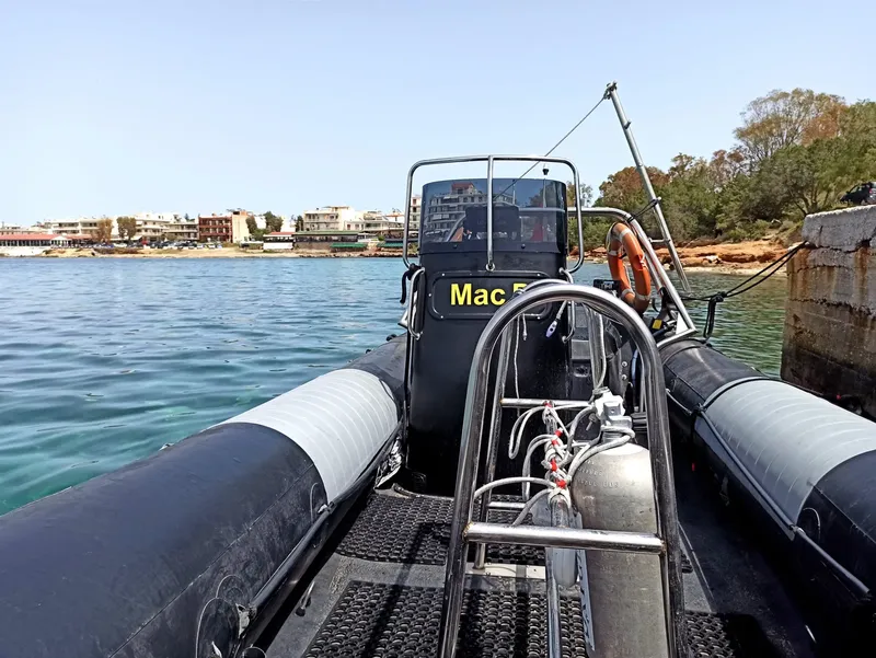 Bateau de plongée amarré au ponton avec bouteilles et vue mer