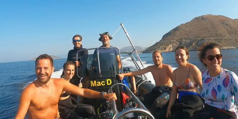 Groupe de personnes souriantes à bord d'un bateau de plongée en mer