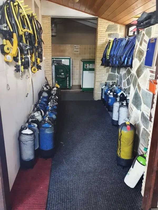 Rangées de bouteilles de plongée et d'équipements dans un local sombre