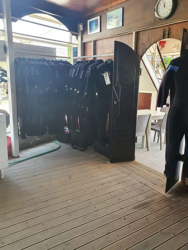 Rangées de combinaisons de plongée noires dans un centre de plongée