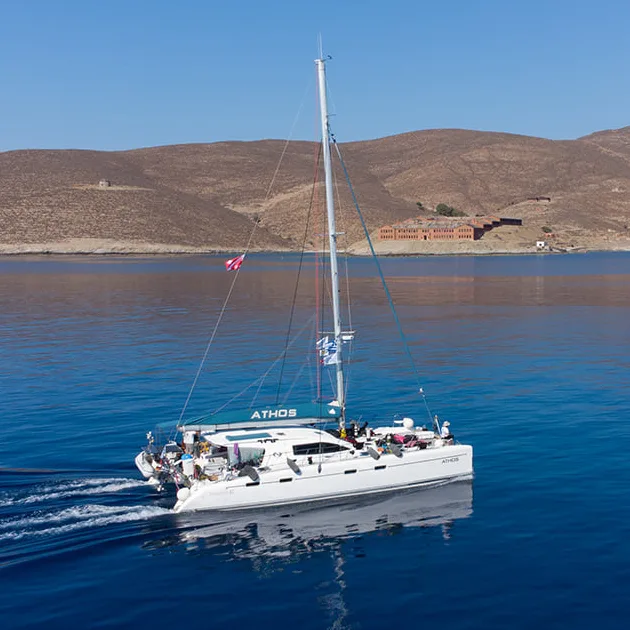 Catamaran à voile navigue sur une mer bleue avec des passagers