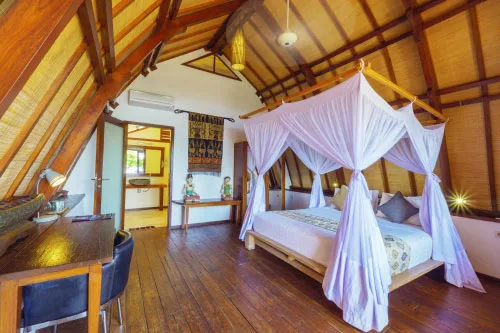 Chambre avec lit à baldaquin en bois, décoration exotique et lumineuse