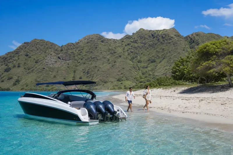 Couple marchant sur une plage avec un bateau à moteur turquoise