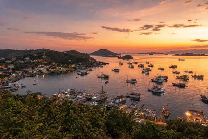 Nombreux bateaux amarrés dans une baie au coucher du soleil