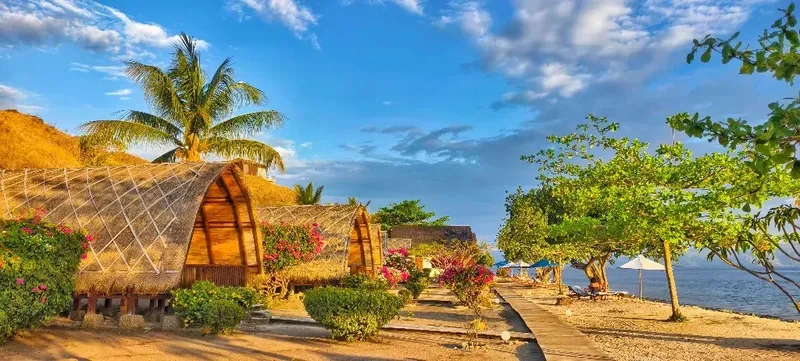Cabanes en bois sur une plage tropicale ensoleillée avec végétation luxuriante
