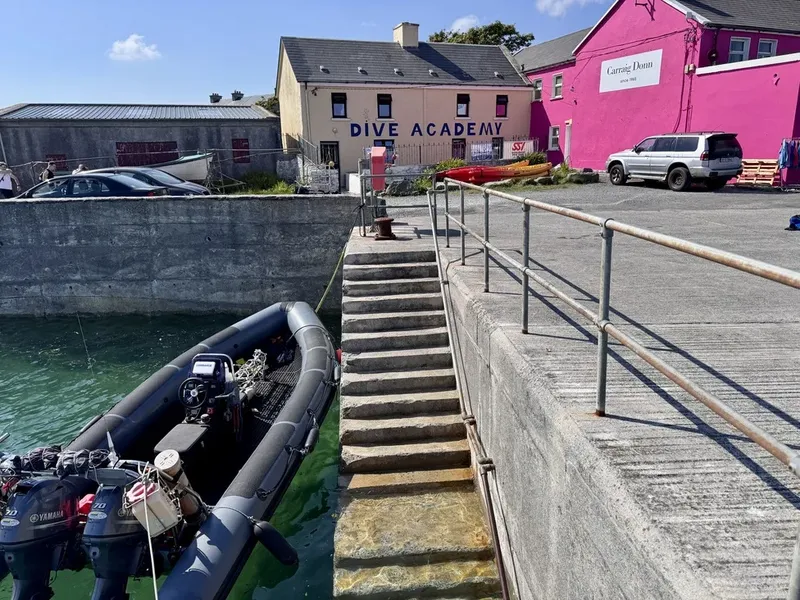 Bateaux amarrés devant un centre de plongée et des escaliers