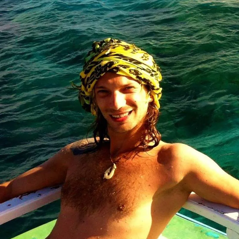 Jeune homme souriant torse nu avec un bandeau sur la tête