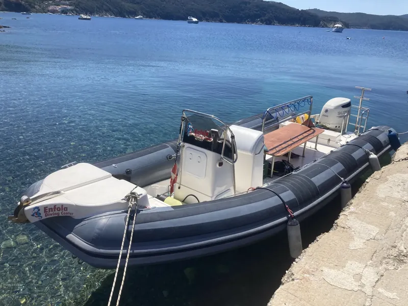 Bateau semi-rigide amarré au quai avec le logo du centre de plongée