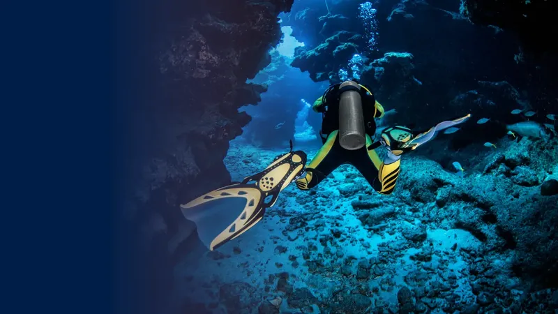 Plongeur explorant une grotte sous-marine avec des poissons et lumière