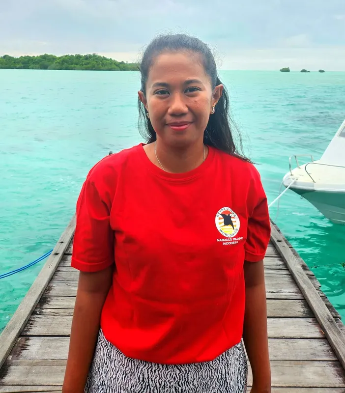 Jeune femme souriante sur un ponton en bois au bord de l'eau